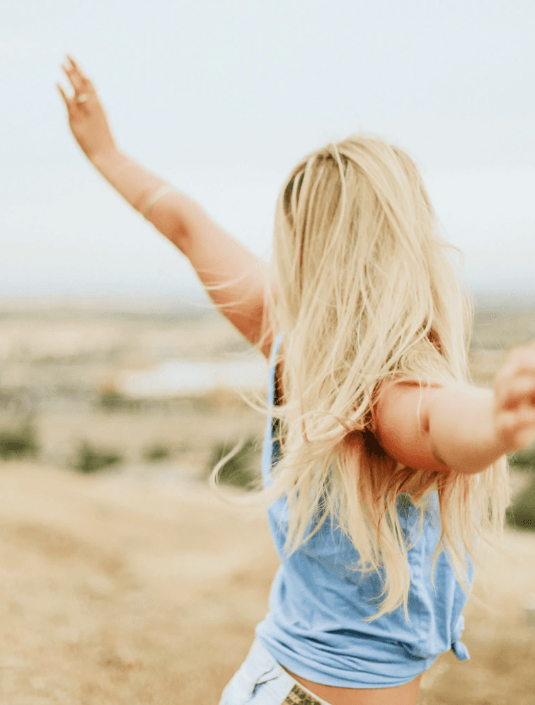 Woman with her arms open in a field