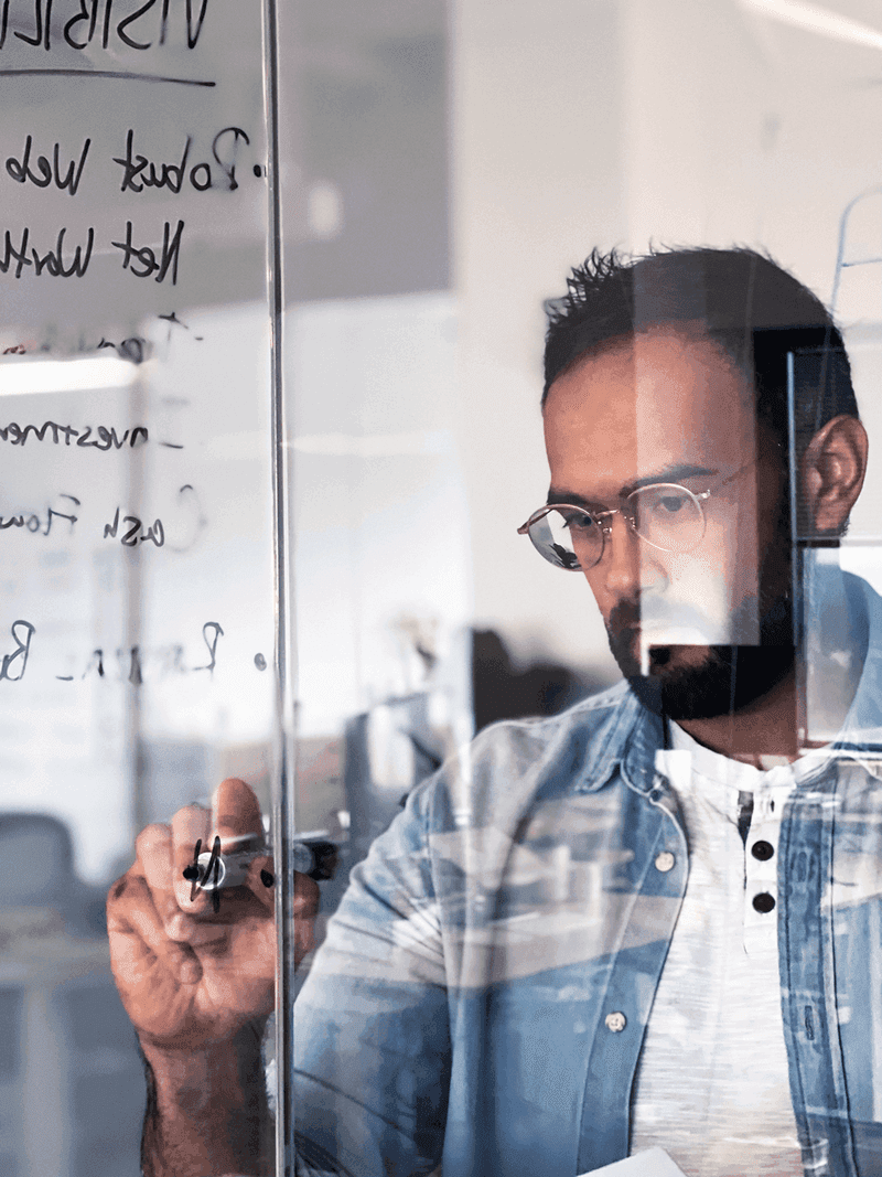 Employee problem-solving on a glass whiteboard